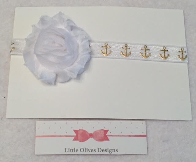white flower with white headband with gold anchors